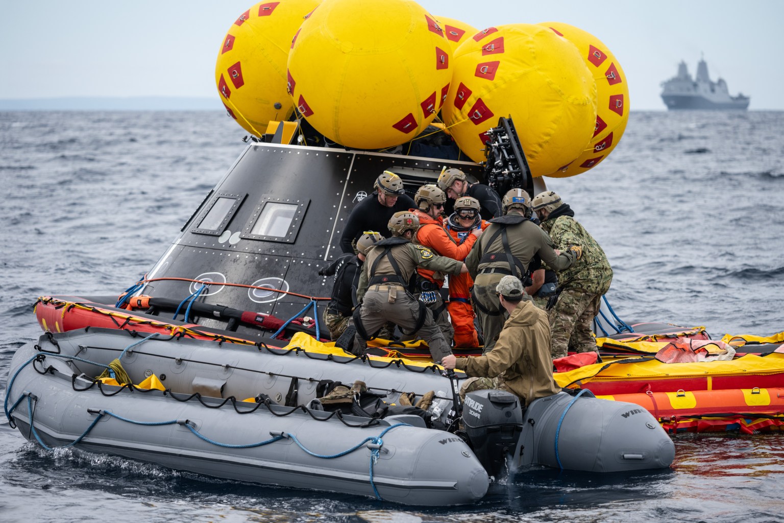 NASA Artemis II crew members are assisted by U.S. Navy personnel as they exit a mockup of the Orion spacecraft in the Pacific Ocean during Underway Recovery Test 11 (URT-11) on Feb. 25, 2024.