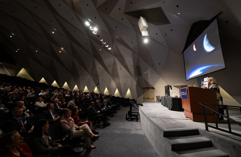 NASA Deputy Administrator Pam Melroy welcomes 2024 Moon to Mars Architecture Workshop attendees from the stage of the Fred Kavli at the National Academy of Sciences in Washington.