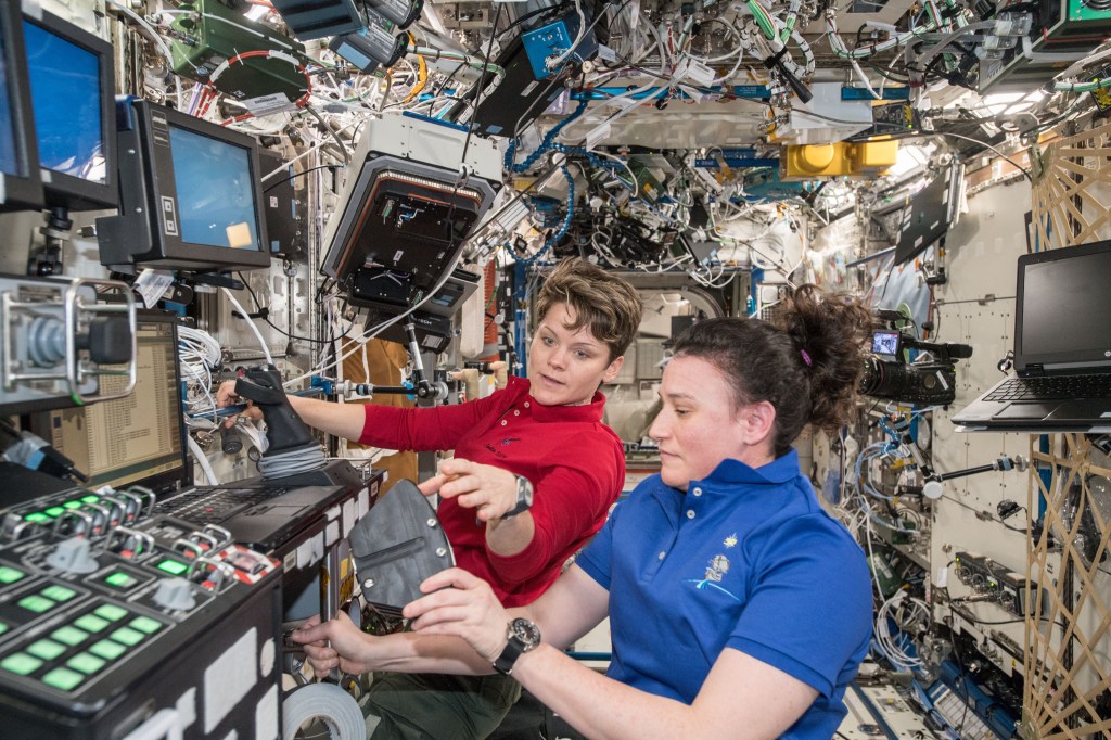 NASA astronauts Anne McClain (background) and Serena Auñón-Chancellor are pictured inside the U.S. Destiny laboratory module.