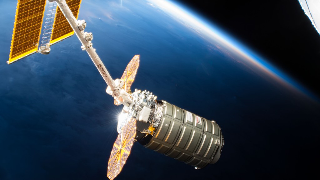 Northrop Grumman's Cygnus space freighter with its prominent cymbal-shaped UltraFlex solar arrays is pictured in the grips of the Canadarm2 robotic arm after it was captured by Expedition 57 Flight Engineer Serena Auñón-Chancellor and ESA (European Space Agency) astronaut Alexander Gerst.