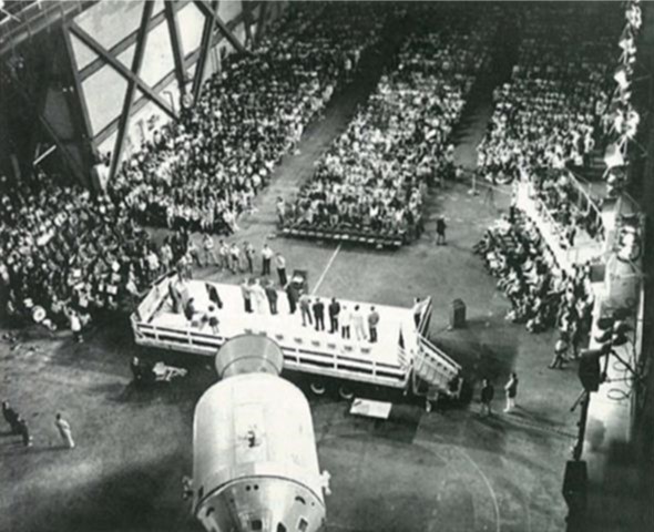 In April 1974, the Skylab 4 astronauts address the assembled employees in the Vehicle Assembly Building at NASA's Kennedy Space Center in Florida