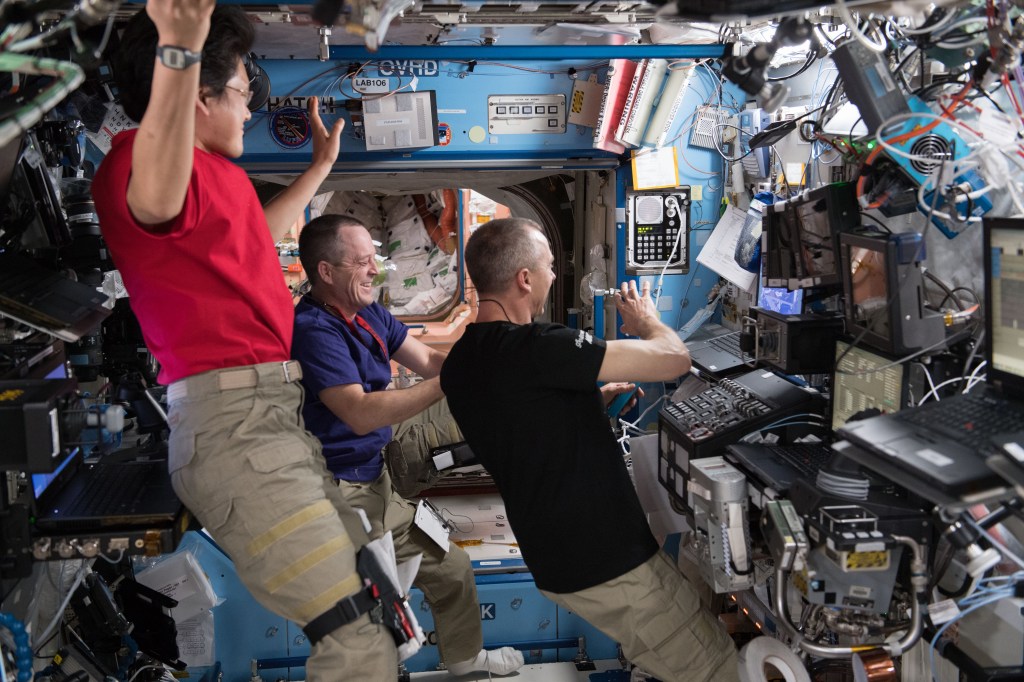 Expedition 55 Flight Engineers (from left) Norishige Kanai, Ricky Arnold and Drew Feustel gather inside the Unity module and take part in a spacewalk procedure conference with specialists on the ground at the Mission Control Center in Houston, Texas.