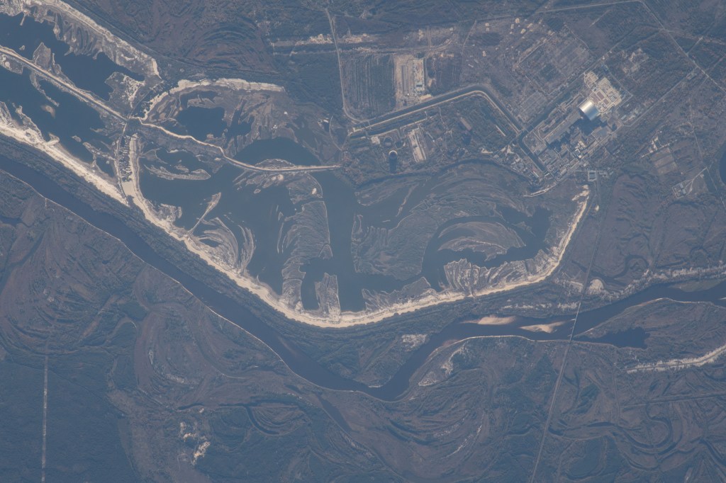 The Chernobyl Nuclear Power Plant on the Pripyat River in northern Ukraine was pictured as the International Space Station orbited 257 miles above Eastern Europe. Across the Ukrainian border in Belarus, the Polesie State Radioecological Reserve was created to enclose territory most affected by radioactive fallout from the Chernobyl disaster.