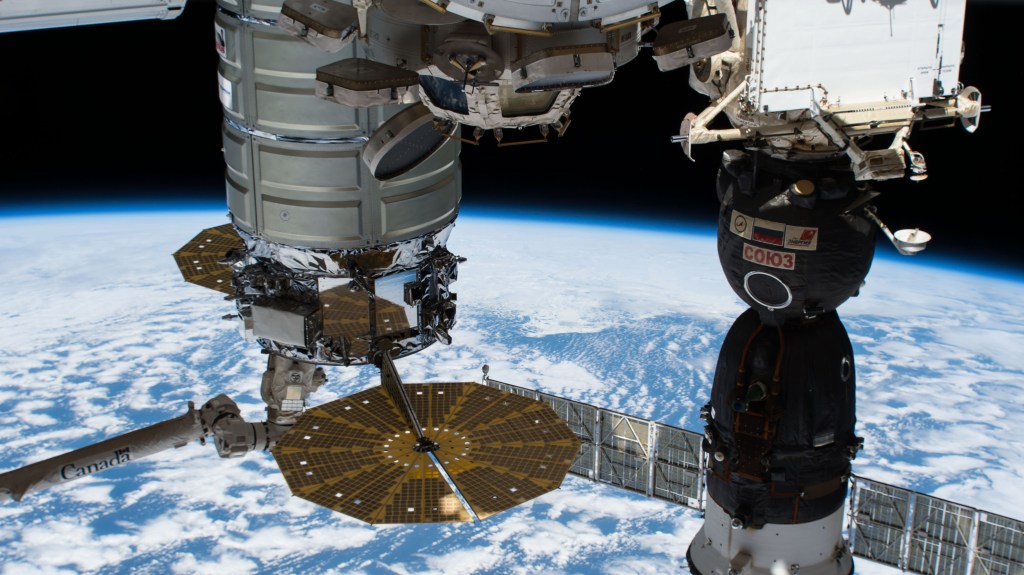 Two spacecraft are pictured attached to the International Space Station as the orbital complex orbited 265 miles above the South Pacific Ocean. At left is the Northrop Grumman Cygnus cargo craft from the United States attached to the Unity module and still in the grip of the Canadarm2 robotic arm. At right is the Russian Soyuz MS-09 crew ship from Roscosmos docked to the Rassvet module.