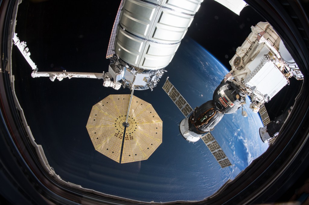 Three spacecraft are pictured attached to the International Space Station as the orbital complex orbited 250 miles above the Bay of Bengal. At center is the Northrop Grumman Cygnus cargo craft from the United States attached to the Unity module and still in the grip of the Canadarm2 robotic arm. To the right of Cygnus is the Russian Soyuz MS-09 crew ship from Roscosmos docked to the Rassvet module. At far right is the Russian Progress 70 cargo craft docked to the Poisk module.
