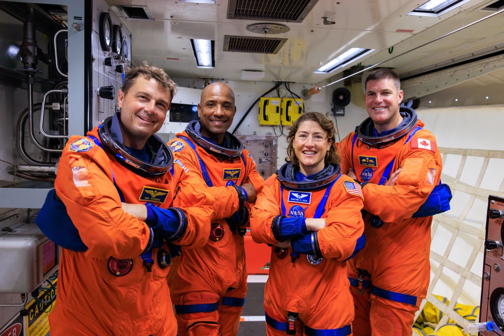  Artemis II astronauts (left to right) Reid Wiseman, Victor Glover, and Christina Koch, and Jeremy Hansen pose for a photo in the white room on the crew access arm of the mobile launcher at Launch Pad 39B as part of an integrated ground systems test at Kennedy Space Center in Florida. Credit: NASA/Frank Michaux 