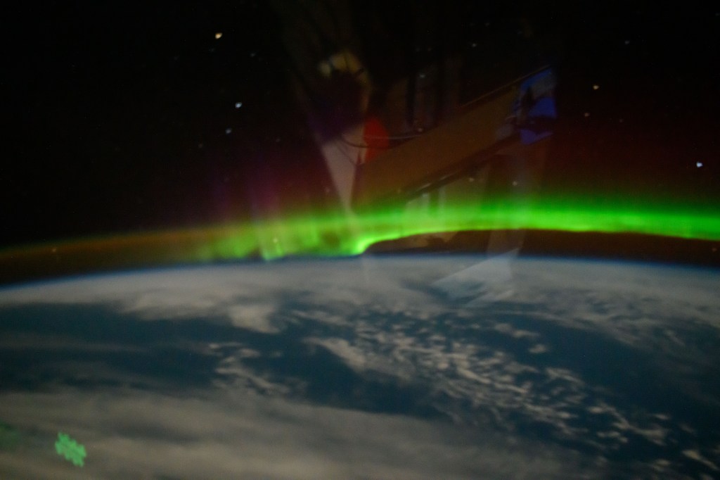 iss070e129324 (March 22, 2024) -- As the International Space Station orbited 263 miles over the Atlantic Ocean, aurora borealis displays ribbons of green light in Earth's night sky.