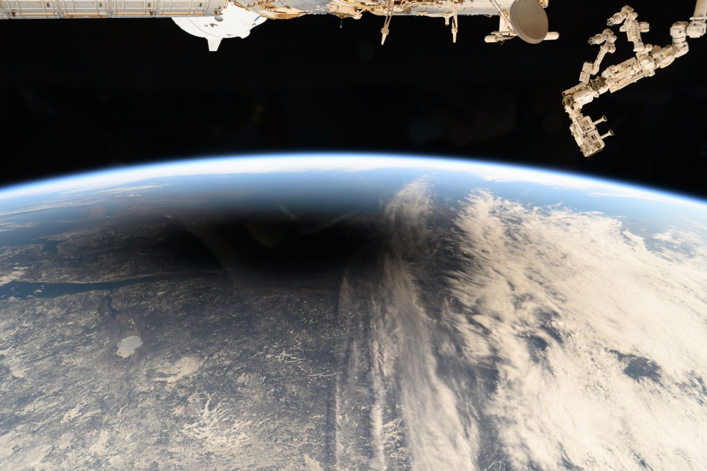 The Moon's shadow, or umbra, is pictured covering portions of the Canadian provinces of Quebec and New Brunswick and the American state of Maine in this photograph from the International Space Station as it soared into the solar eclipse from 261 miles above.