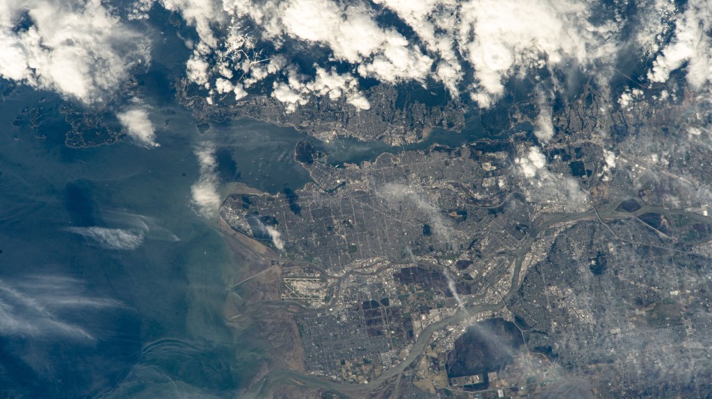Vancouver, British Columbia, and its surroundng suburbs on the Strait of Georgia are pictured from the International Space Station as it orbited 261 miles above Canada. Toward lower center, is the Fairmont Vancouver Airport on Sea Island.