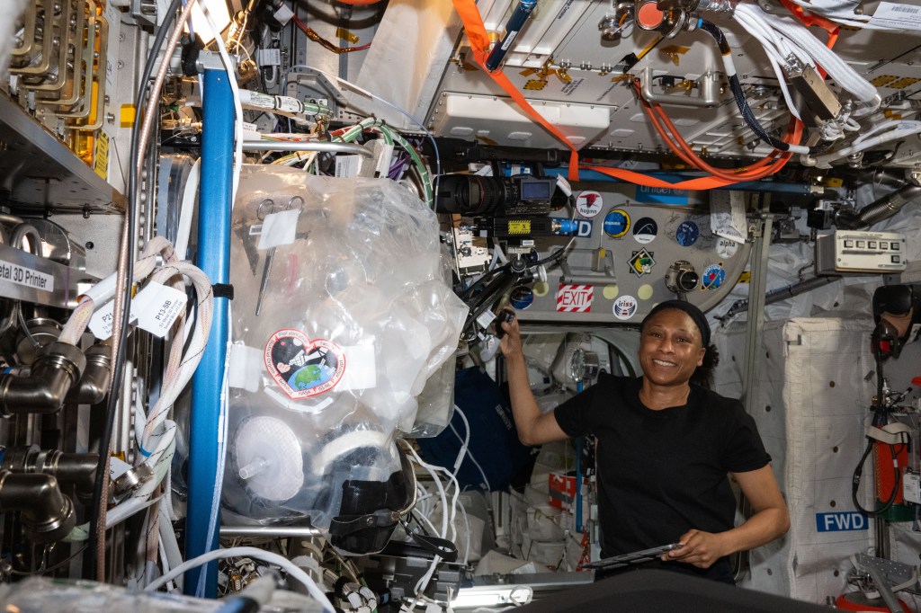 Expedition 70 Flight Engineer and NASA astronaut Jeanette Epps smiles for a portrait abaord the International Space Station's Columbus laboratory module. She had finished conducting a HAM radio session with Italian students who asked Epps several questions about living and working in space.