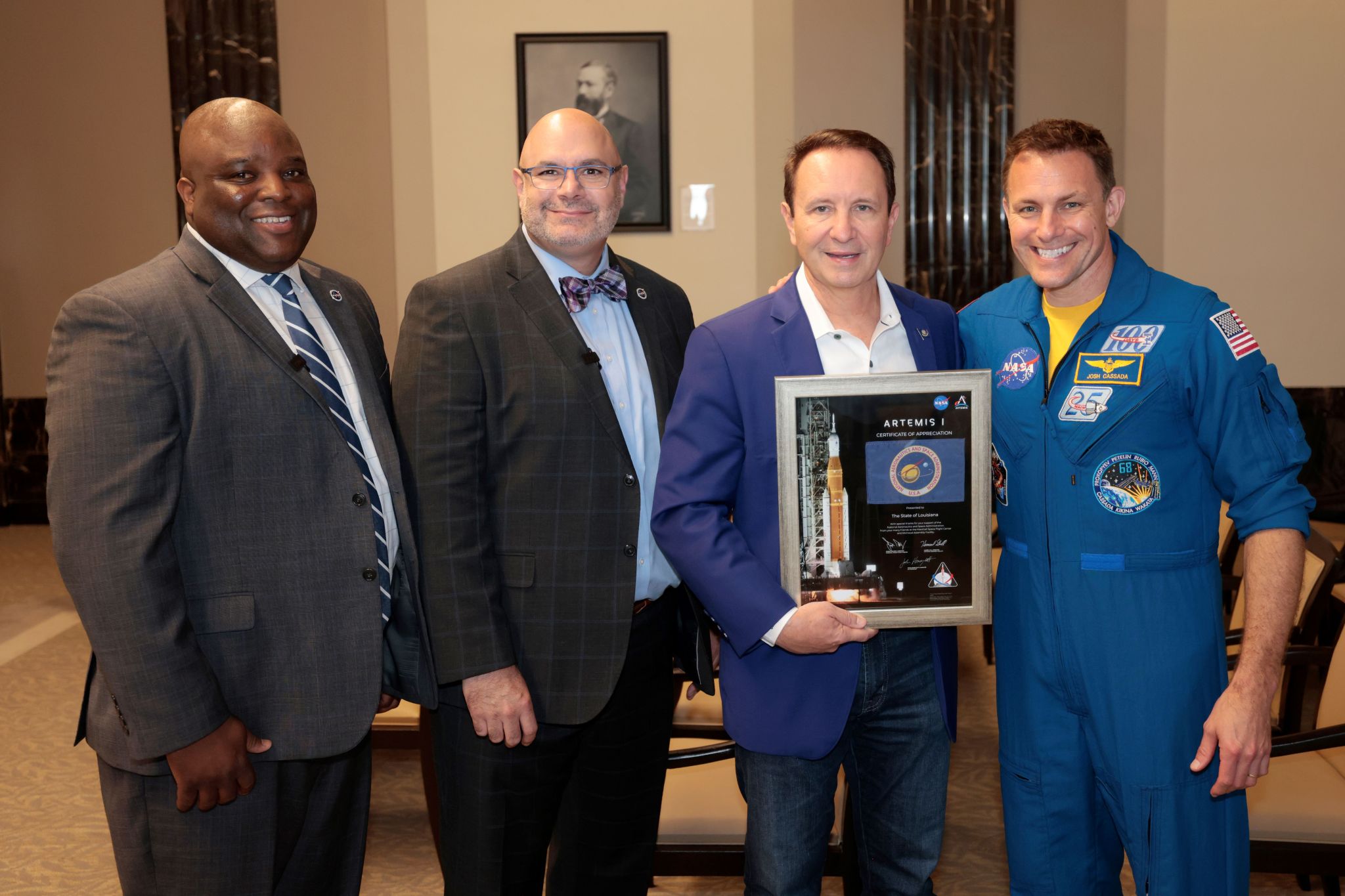 From left, NASA Michoud Assembly Facility Director Hansel Gill, Pelfrey, Louisiana Gov. Jeff Landry, and Cassada pose with an Artemis I-flown flag presented to the governor during Louisiana Space Day.