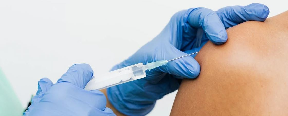 person receiving an injection in their upper arm