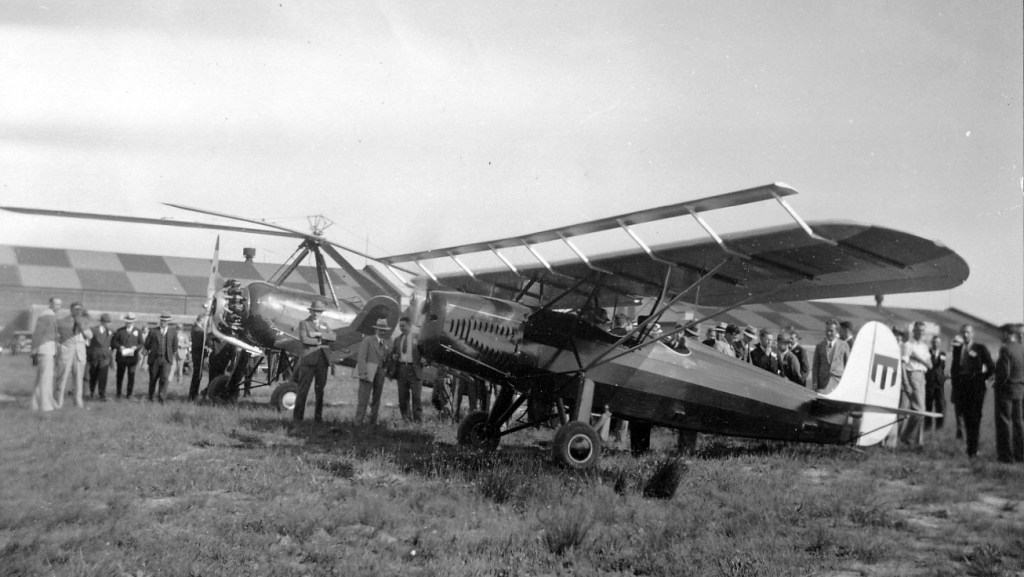 People standing next small aircraft.