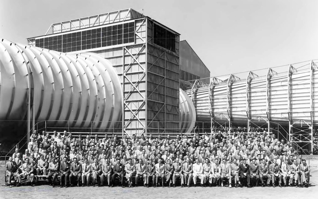 Group posing for photo in front of wind tunnel.