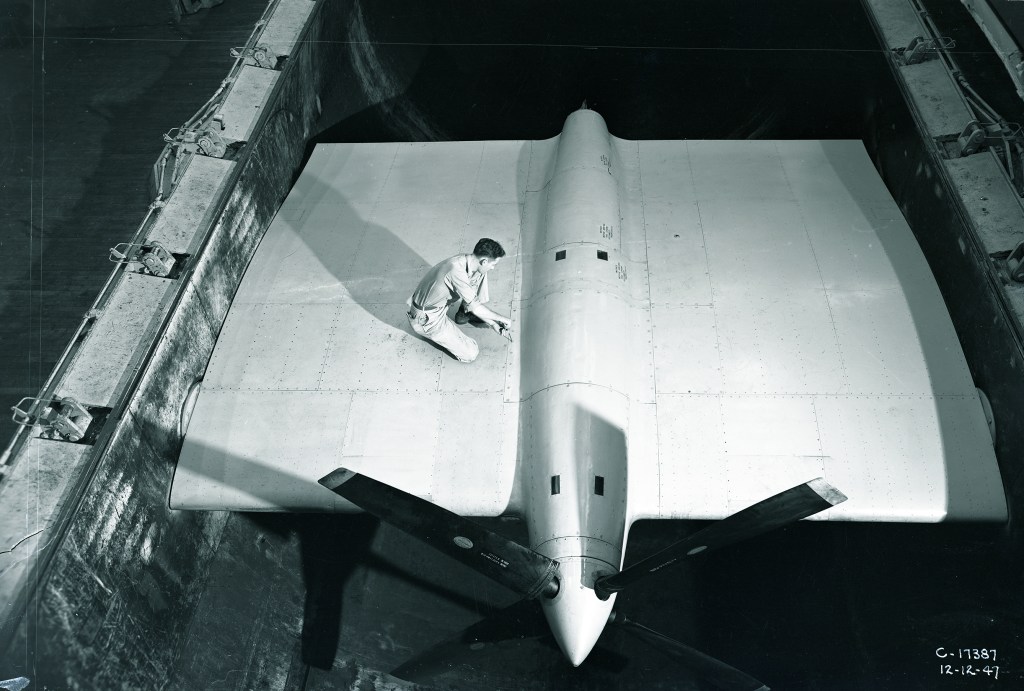 Man on wing span in wind tunnel.