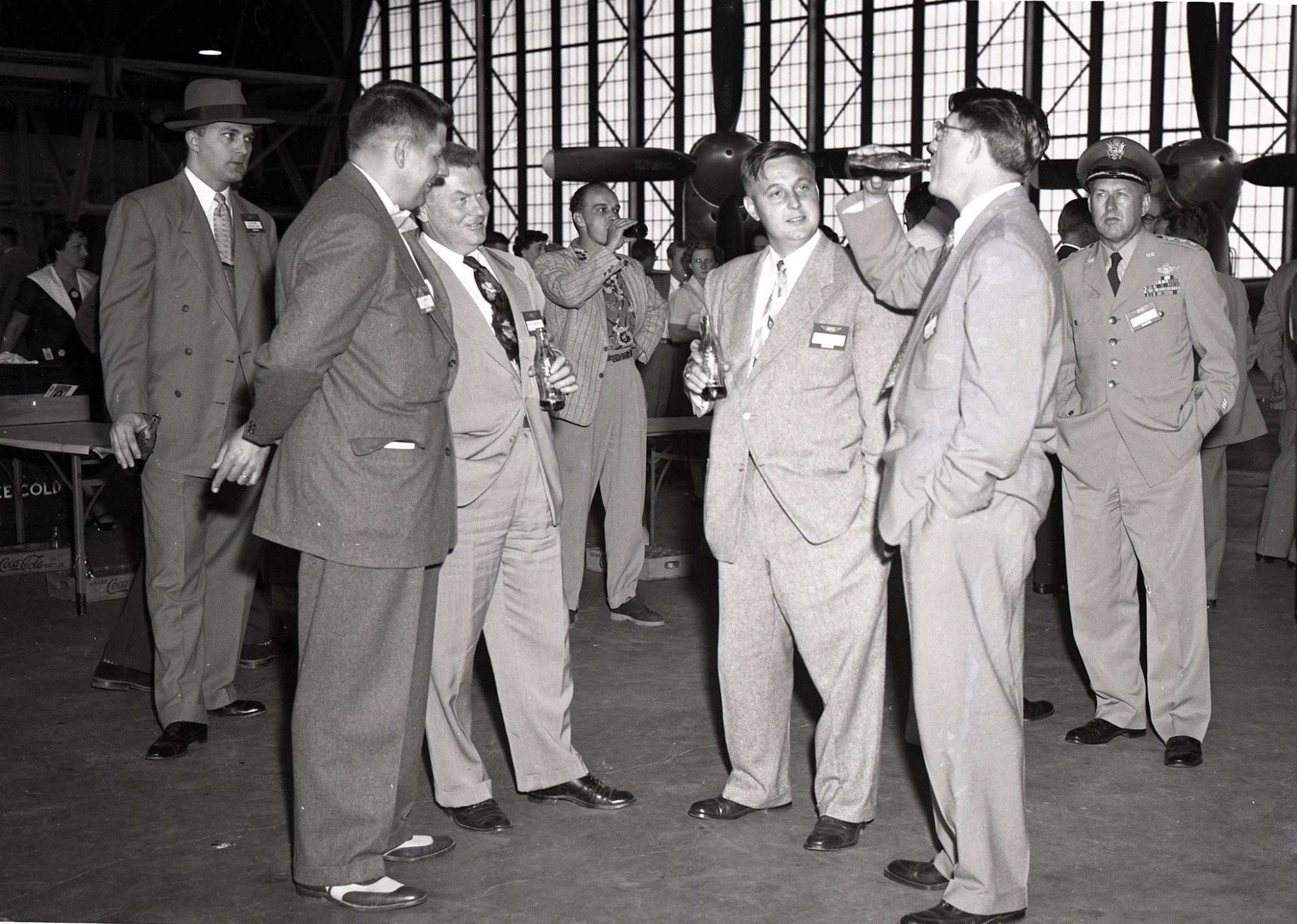 Men standing in hangar.