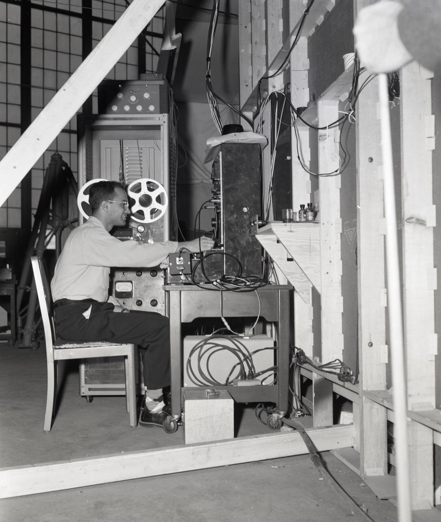 Man seated with equipment.