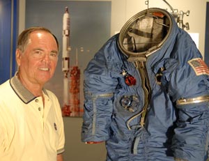 Former MOL and NASA astronaut Robert L. Crippen stands next to the spacesuit developed for the MOL program