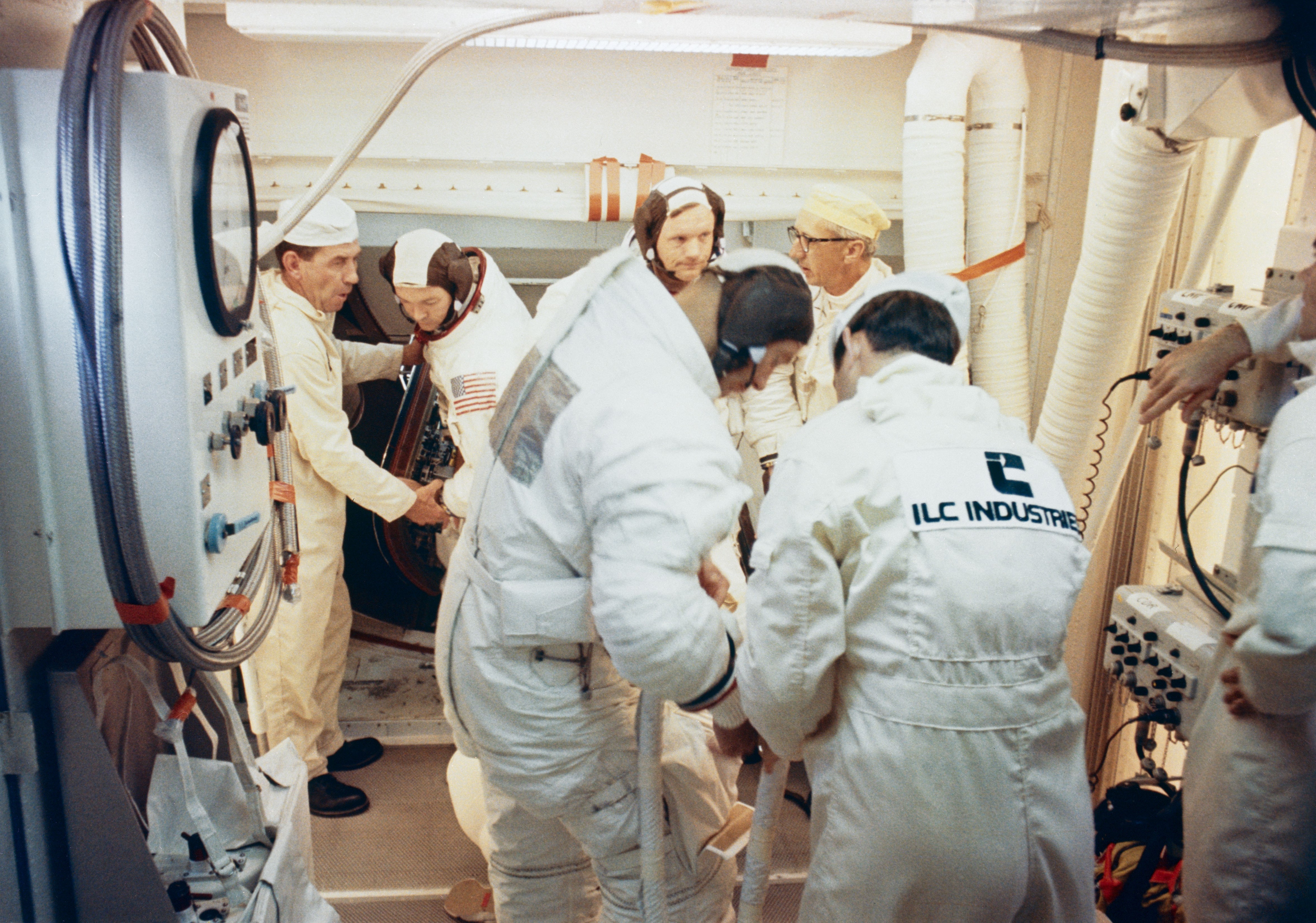 Workers in the White Room assist Collins, left, Armstrong, and Aldrin to enter their spacecraft for the CDDT