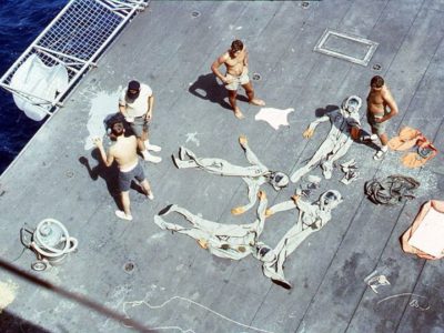 Recovery team members dry their Biological Isolation Garments aboard the U.S.S. Hornet following a recovery exercise