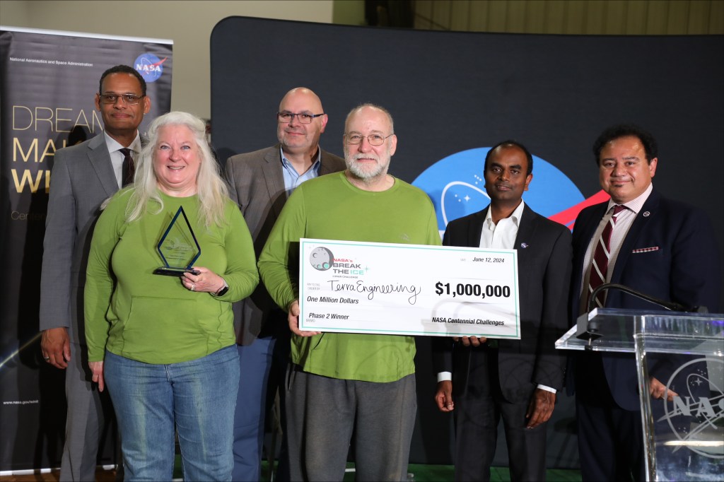 The husband-and-wife duo of Terra Engineering, Valerie and Todd Mendenhall, receive the $1 million prize June 12, for winning the final phase of NASA’s Break the Ice Lunar Challenge at Alabama A&M’s Agribition Center in Huntsville. With the Terra Engineering team at the awards ceremony are from left, Daniel K. Wims, Alabama A&M University president; Joseph Pelfrey, NASA Marshall Space Flight center director; NASA’s Break the Ice Challenge Manager Naveen Vetcha, and Majed El-Dweik, Alabama A&M University’s vice president of Research & Economic Development.