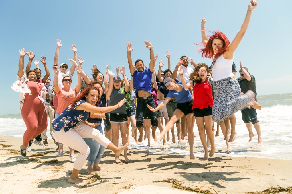 Interns visiting Wallops Flight Facility jumping in a fun photo at the Wallops Island Beach