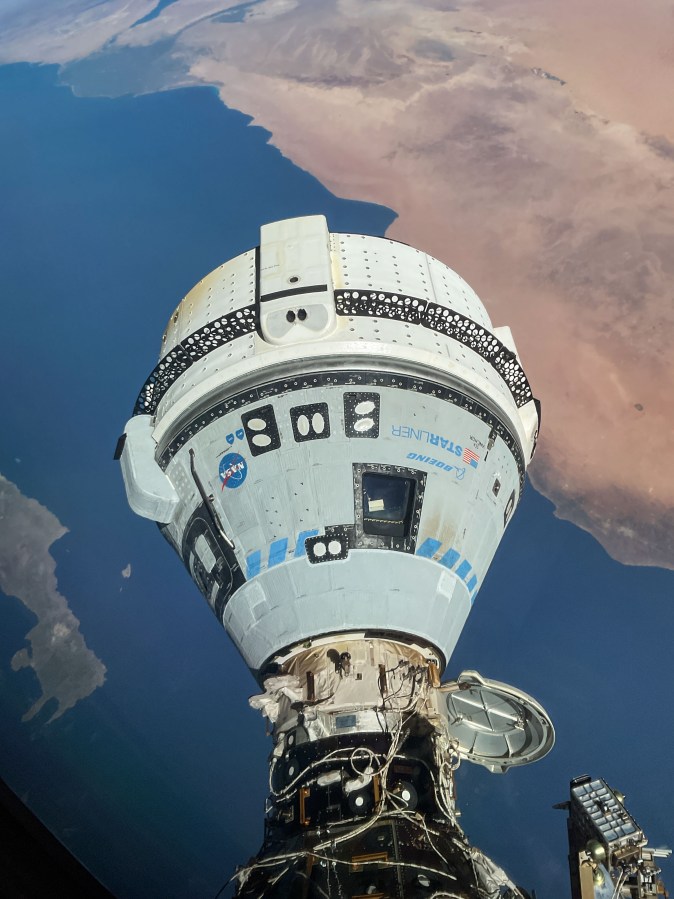 Looking down at Boeing's Starliner spacecraft attached to the International Space Station.