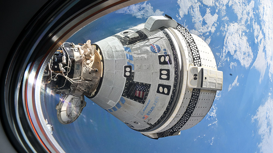 Boeing's Starliner spacecraft is pictured from a window on the SpaceX Dragon Endeavour spacecraft docked to the Harmony module's forward port.