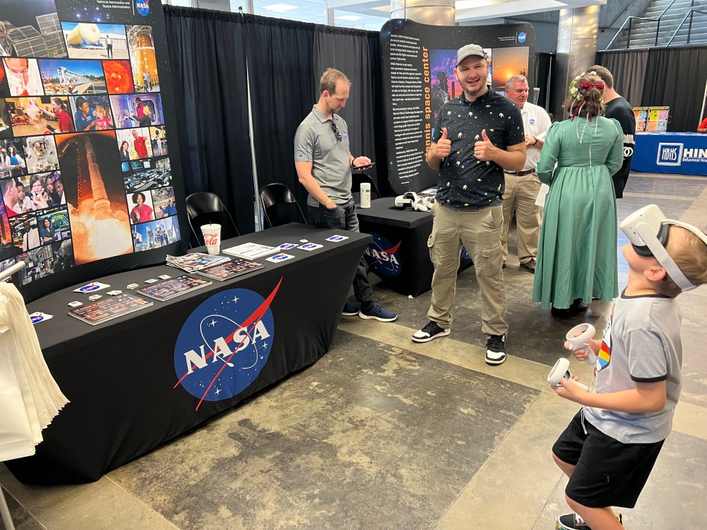 a young fan has a virtual reality experience in space when he stops at the NASA Stennis booth at Mississippi Comic Convention