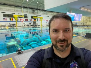 Dane Turner (posing for a selfie in front of the Neutral Buoyancy Laboratory), multimedia content producer and host of Houston We Have a Podcast.