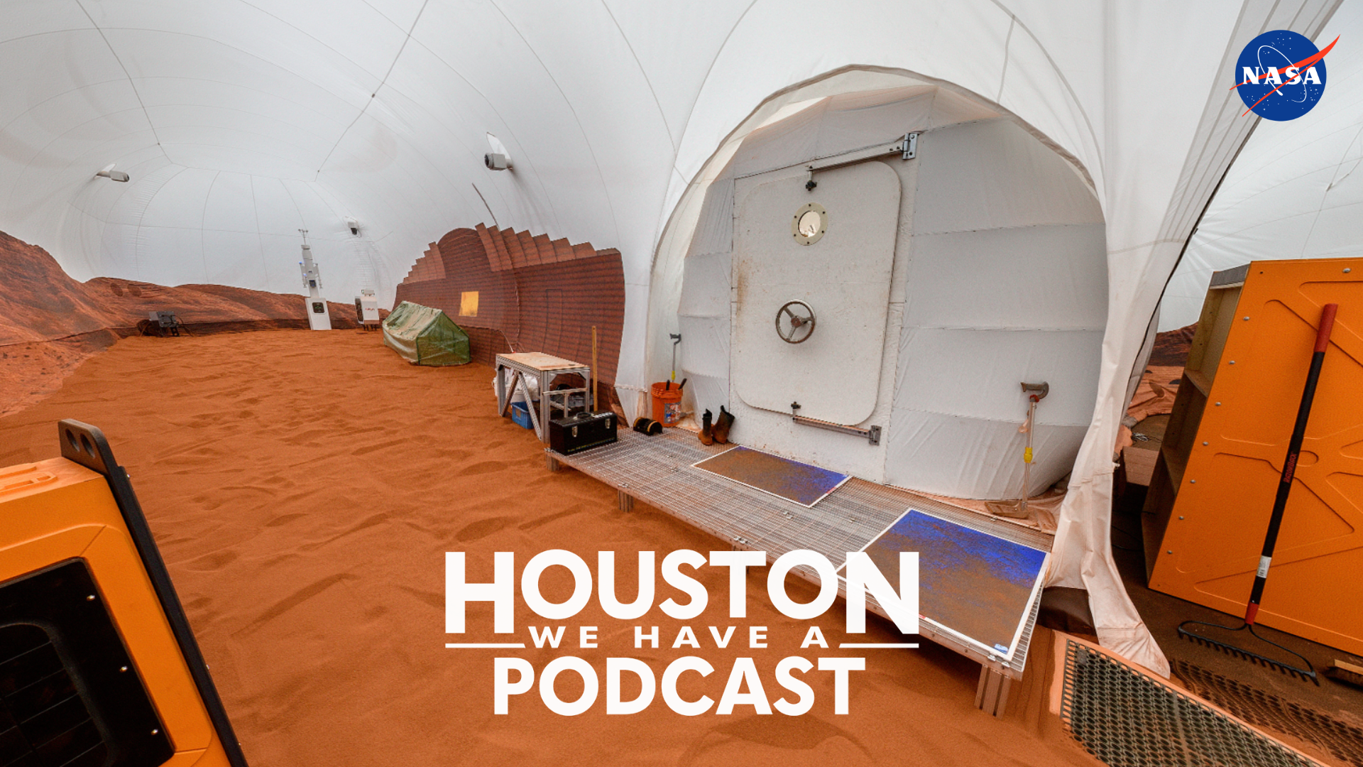 Houston We Have a Podcast Ep. 346: Mars Audio Log #12. Image shows the HWHAP logo in white text at the bottom of the image. The text overlays a photo of the 1,200 square-foot sand box located at the CHAPEA habitat. The sandbox is Mars-realistic, with rust-colored dust and regolith.
