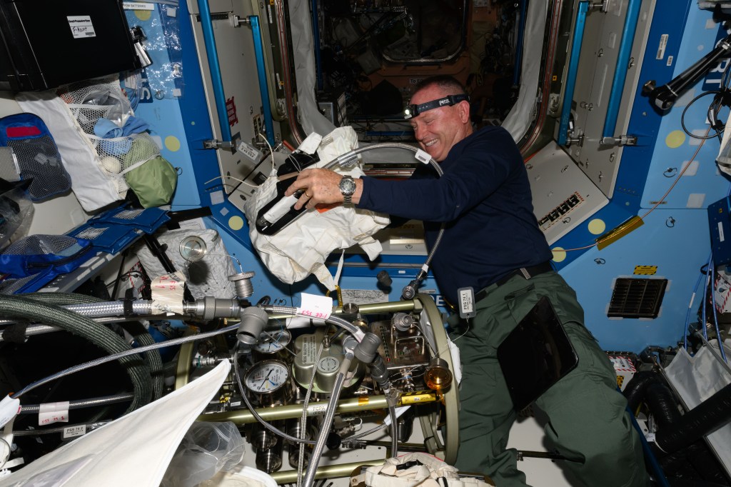 NASA astronaut and Boeing Crew Flight Test Commander Butch Wilmore works on the Fluid Systems Servicer which drains, purges, and circulates fluids on systems aboard the International Space Station.