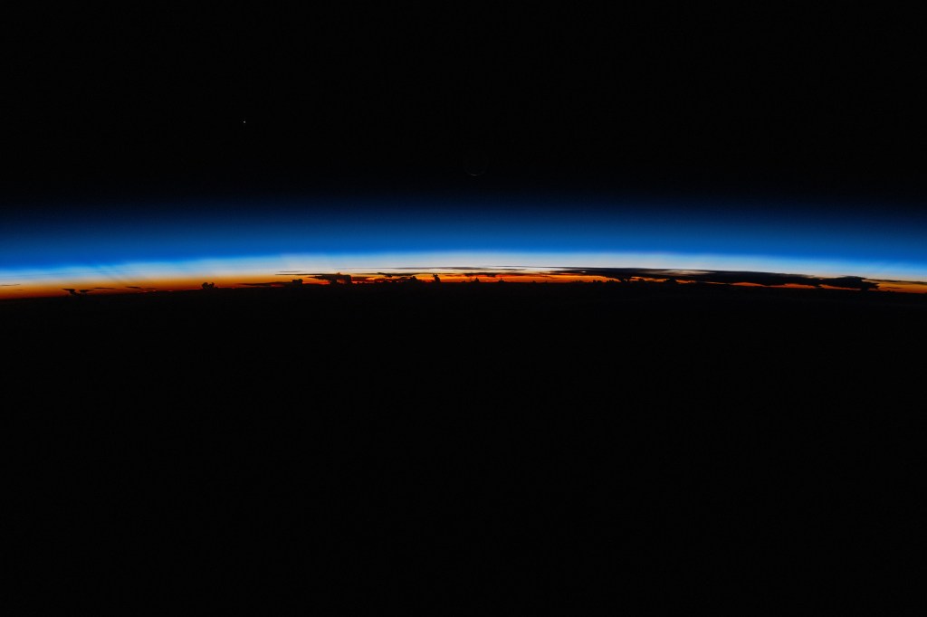 iss071e310017 (July 6, 2024) -- The last rays of an orbital sunset shine a striking orange against Earth's blue glow as the International Space Station orbited 255 miles above The Philippines.