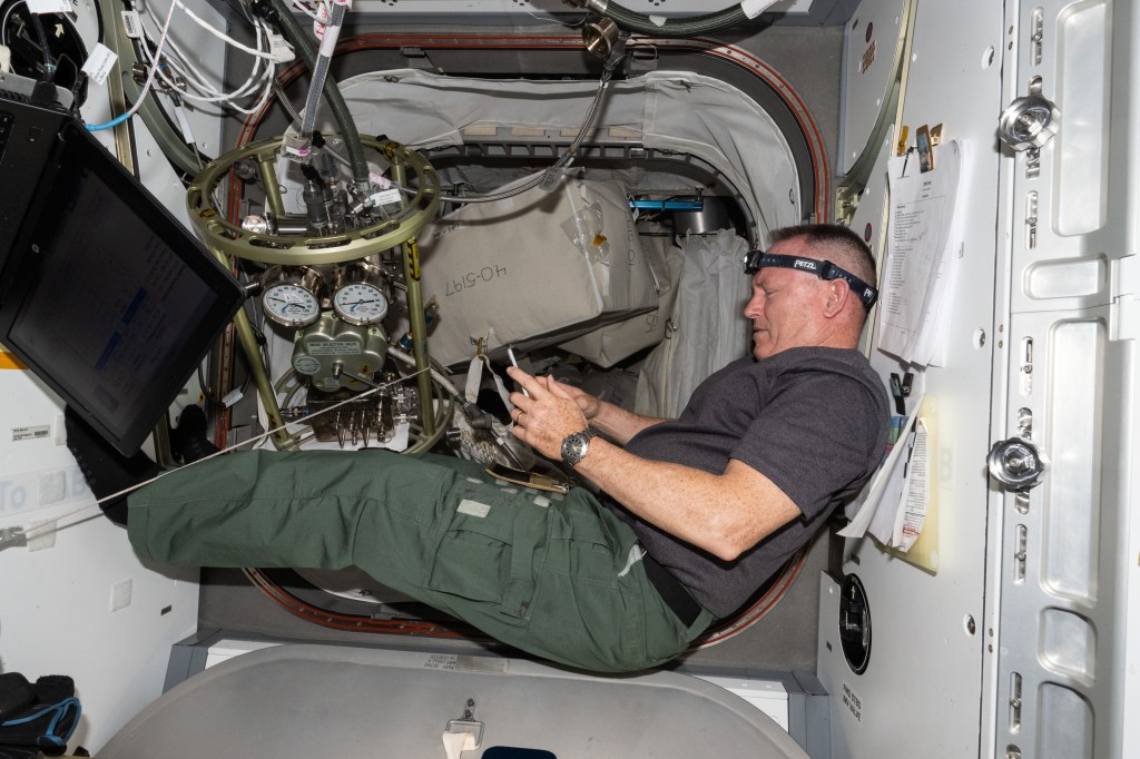 NASA astronaut and Boeing's Crew Flight Test Commander Butch Wilmore reviews procedures on a computer tablet for life support maintenance work aboard the International Space Station.
