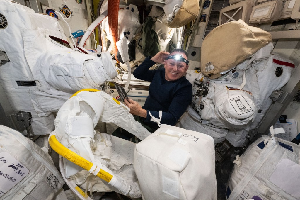 NASA astronaut and Boeing Crew Flight Test Commander Butch Wilmore performs spacesuit maintenance inside the International Space Station's Quest airlock.