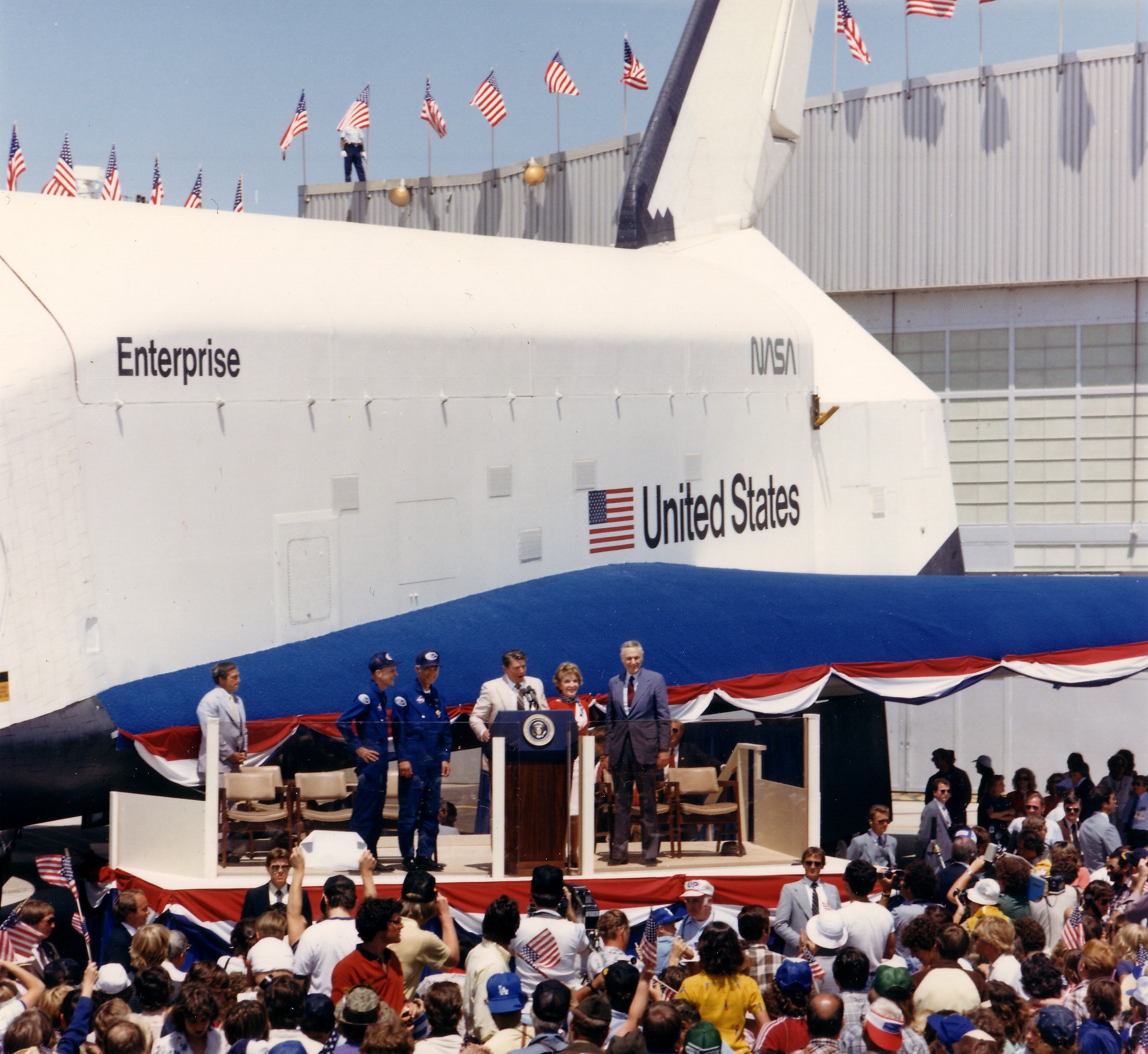 With space shuttle Enterprise as a backdrop, President Ronald W. Reagan, First Lady Nancy Reagan, and NASA Administrator James M. Beggs welcome home STS-4 astronauts Thomas K. “TK” Mattingly and Henry W. Hartsfield