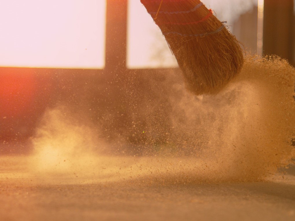 Broom sweeping up sand.