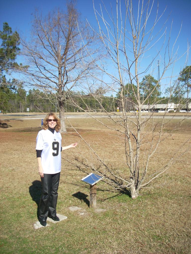 Rosemary Roosa, daughter of the late Apollo 14 astronaut Stuart Roosa, poses next to the moon tree planted at Stennis Space Center
