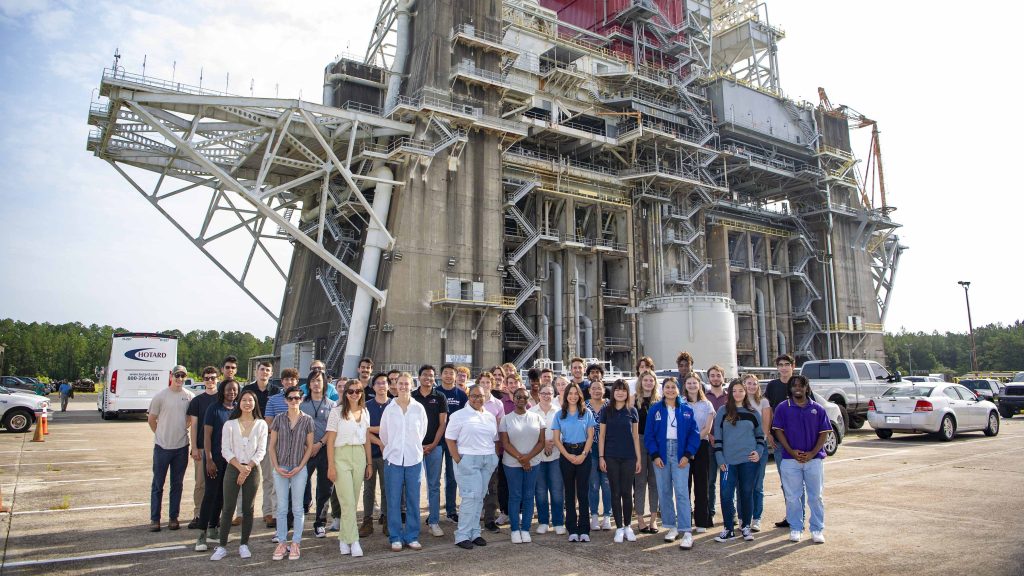 Interns at NASA Stennis pose for photo in front of the Thad Cochran Test Stand