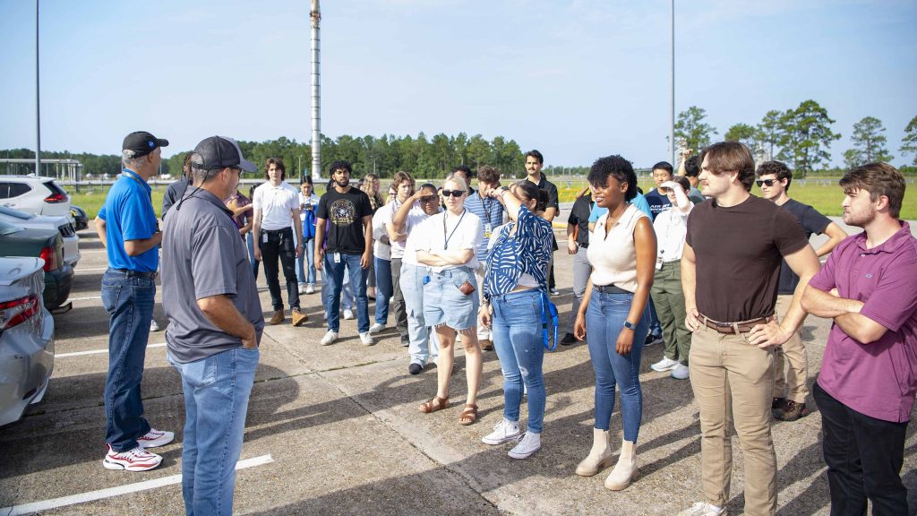 NASA Stennis supervisors greet site interns in the parking lot before leading them on a tour of the Thad Cochran Test Stand