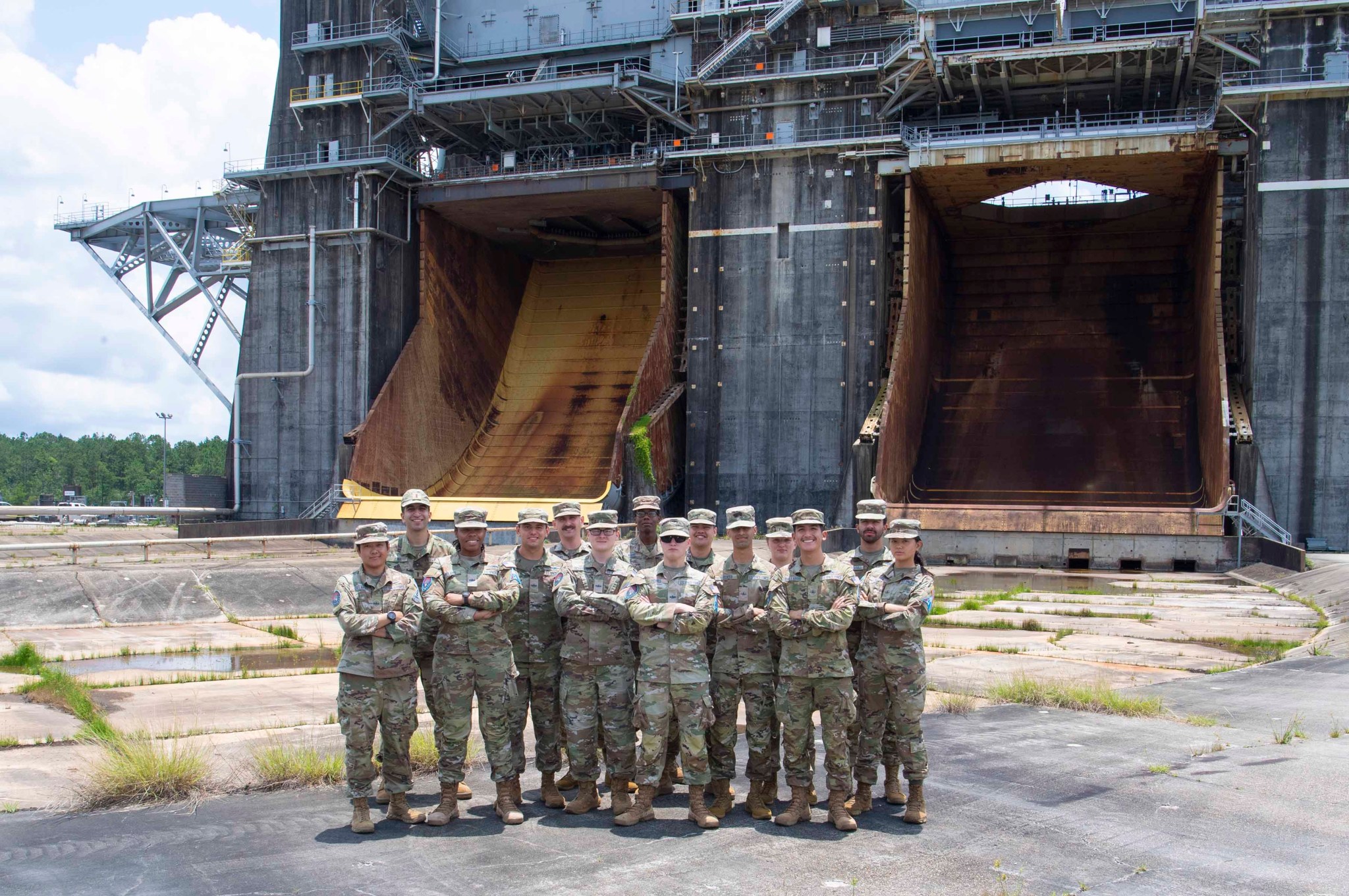 a group of United States Space Force training students and professors stand at the Thad Cochran Test Stand