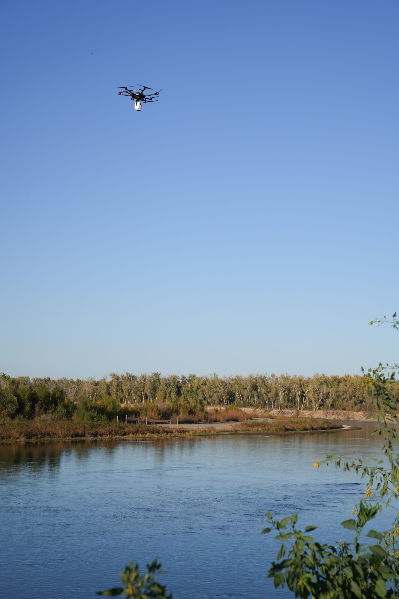 A UAV with the Streamflow thermal mapping payload flying above the Sacramento river.