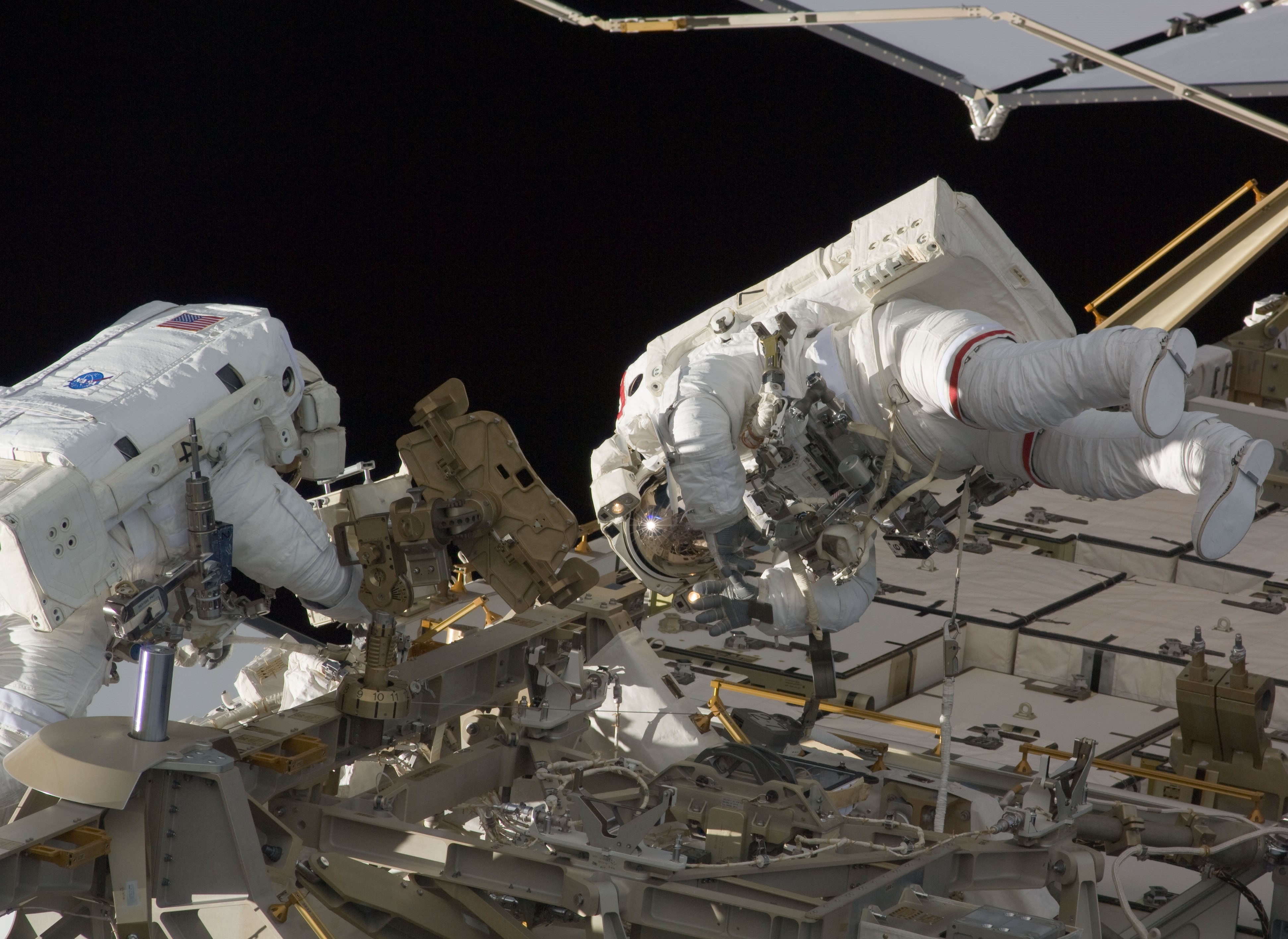 Timothy L. Kopra, left, and David A. Wolf work on the station’s truss during the mission’s first spacewalk