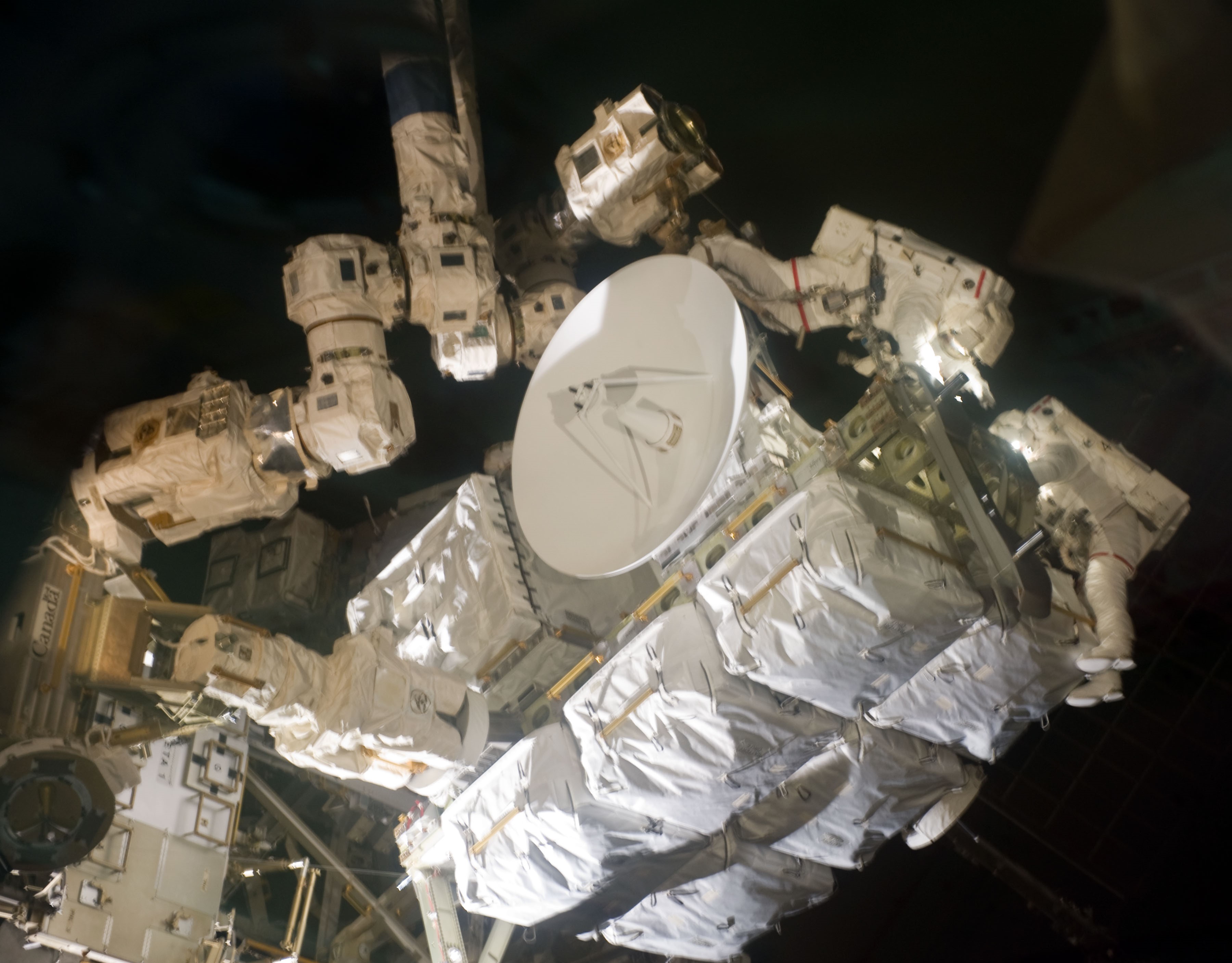 During the second spacewalk, David A. Wolf, left, and Thomas H. Marshburn transfer spare parts to the space station