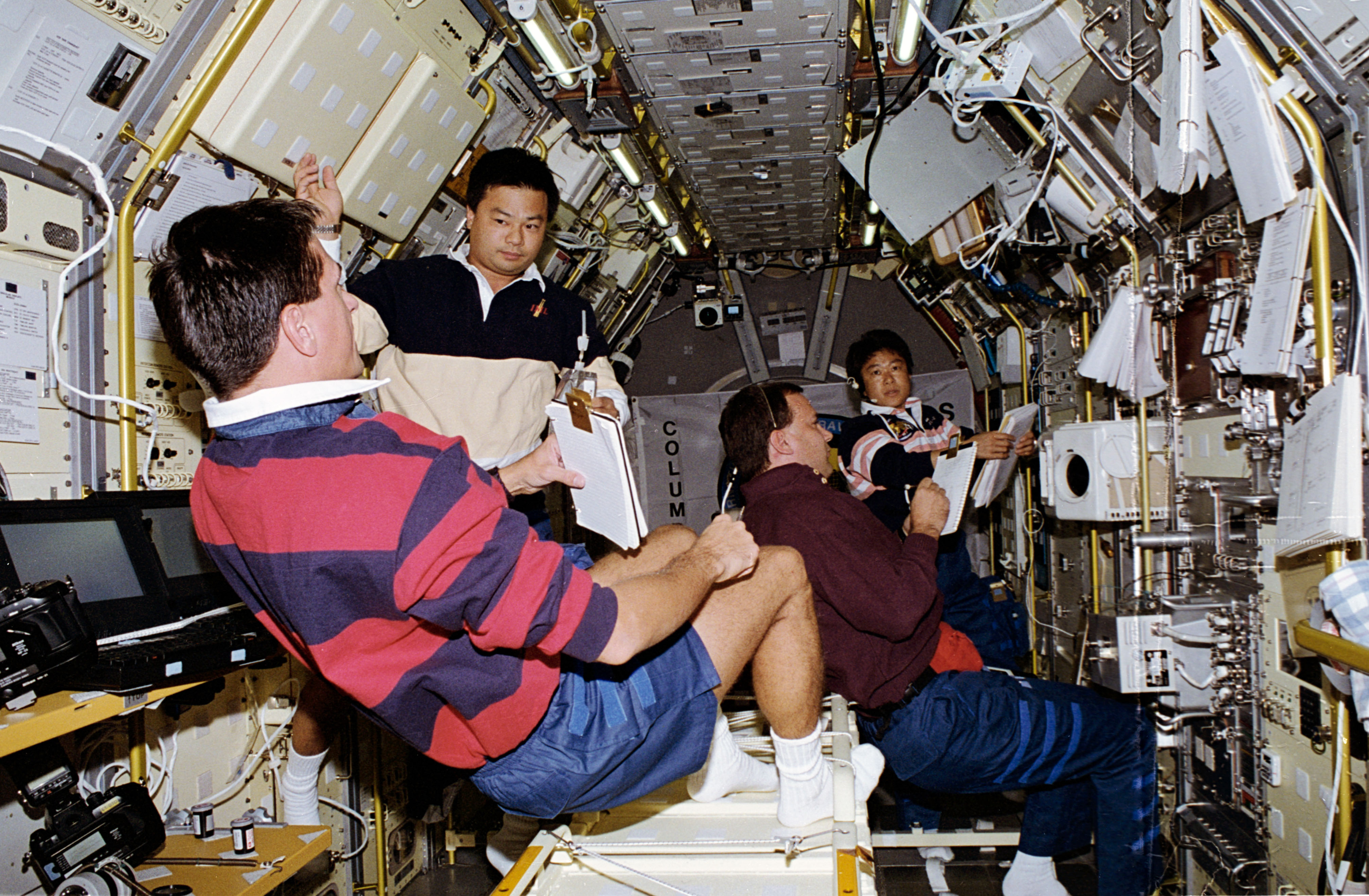 Donald A. Thomas, left, Leroy Chiao, Richard J. Hieb, and Chiaki Mukai at work in the Spacelab module