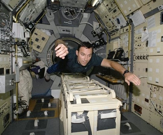Carl E. Walz flies through the Spacelab module