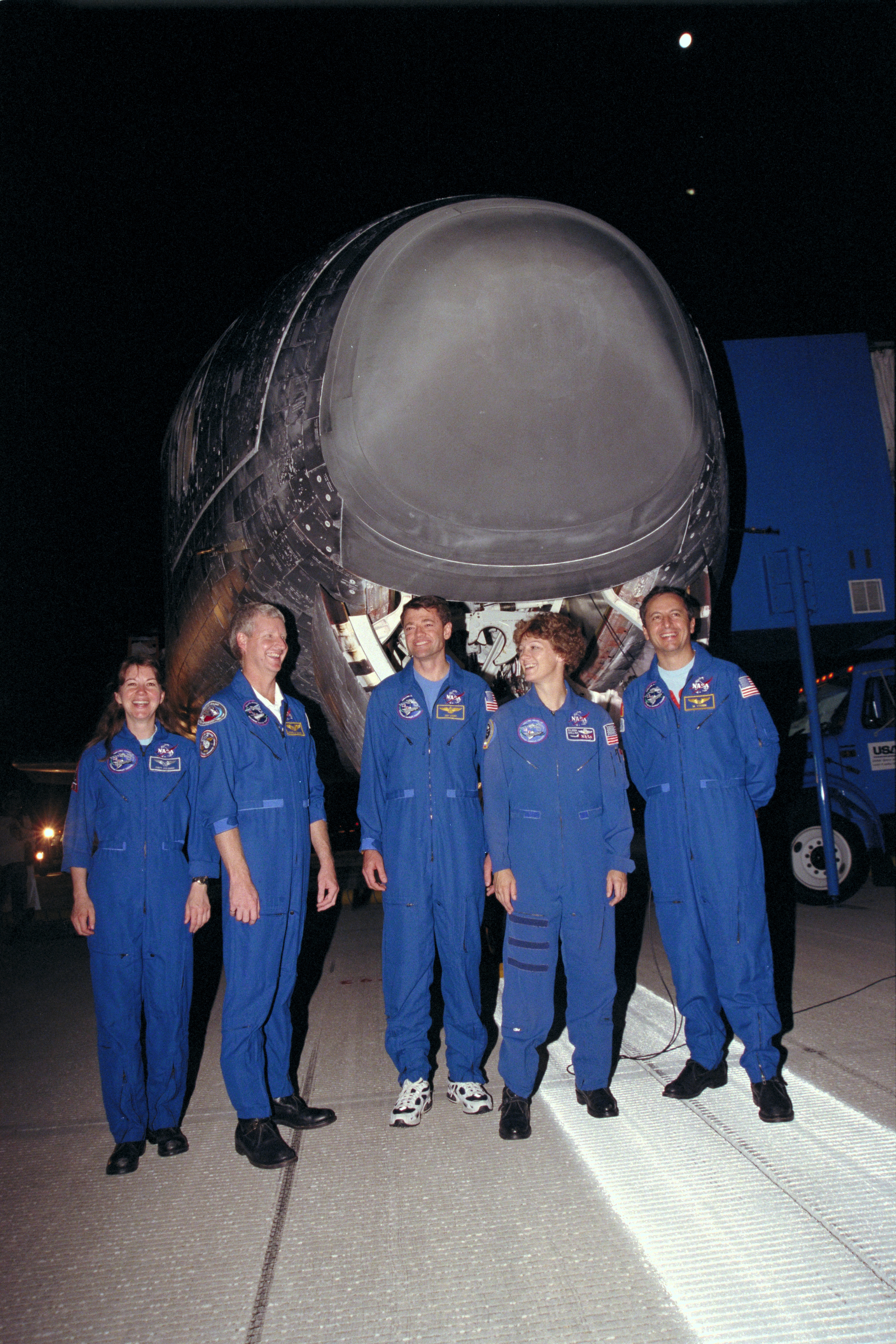 The STS-93 crew pose in front of Columbia on the Shuttle Landing Facility at NASA's Kennedy Space Center in Florida