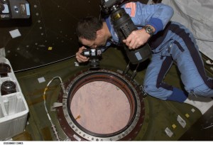 NASA astronaut Don Pettit uses a still camera to photograph the topography of a point on Earth from the nadir window in the Destiny laboratory on the International Space Station. Credit: NASA