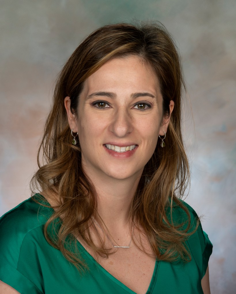 Portrait of a woman wearing a green shirt.