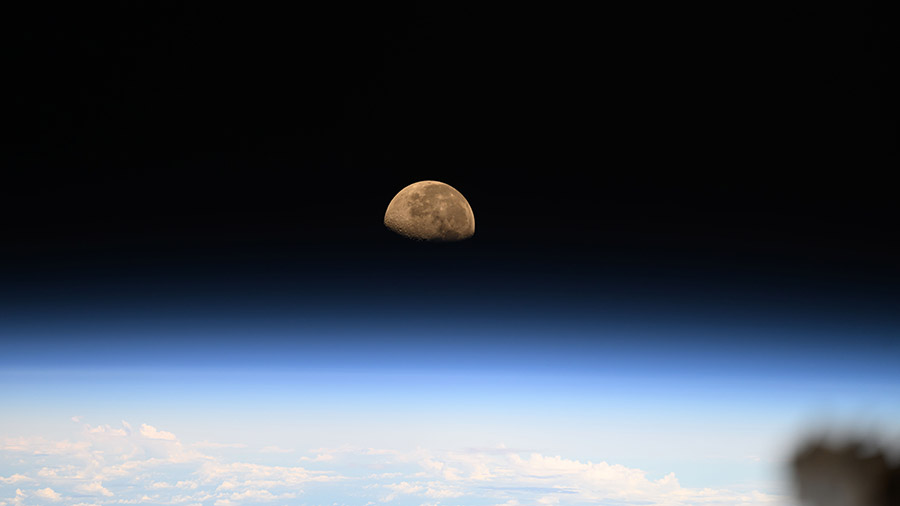 A waning gibbous moon sets over the Pacific Ocean as the International Space Station orbited 258 miles above.